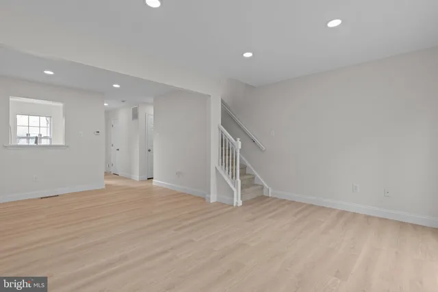 a view of an empty room with wooden floor