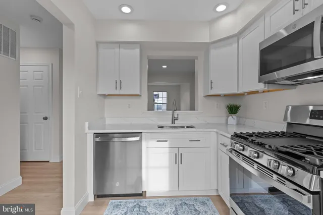 a kitchen with stainless steel appliances granite countertop a stove a sink and a microwave