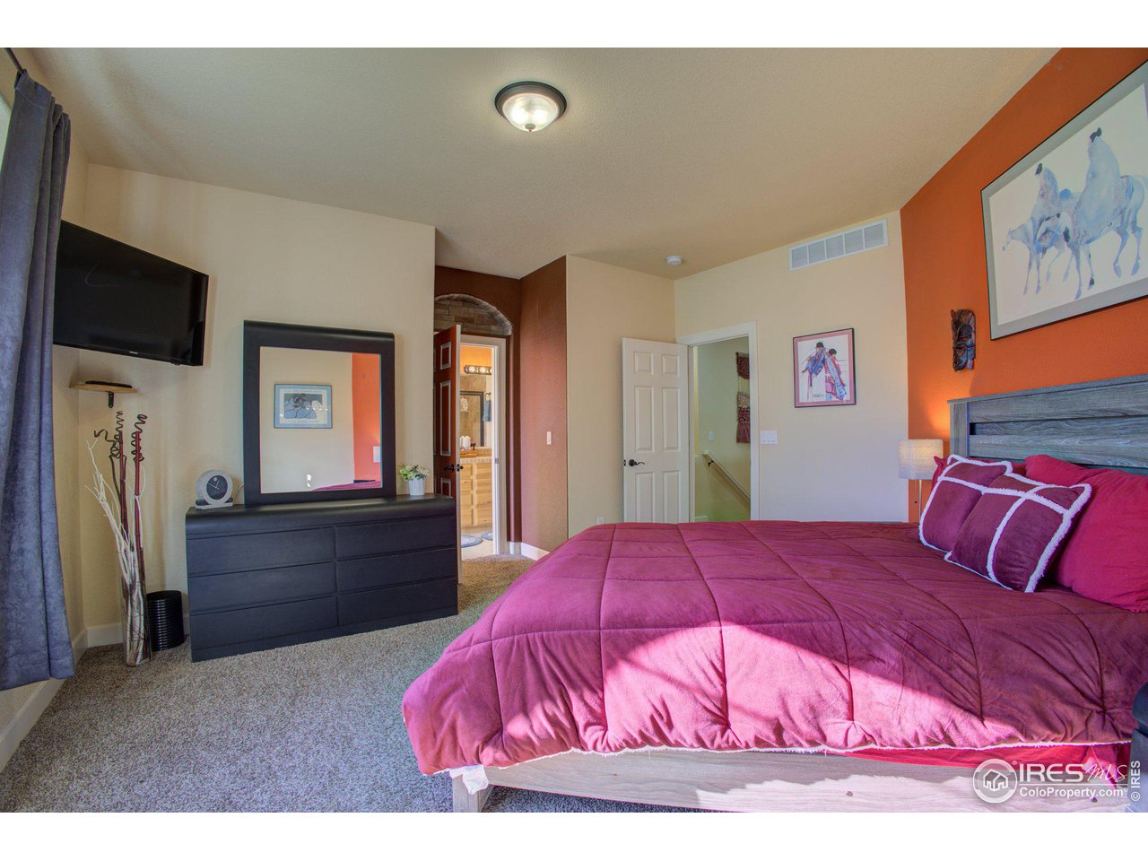 1515 Waterfront Drive Windsor, CO 80550 - Photo 20 of 40 Southern sunlight fills the primary bedroom through the boxed window. You can see into the primary ensuite bath through the door in the center of this picture