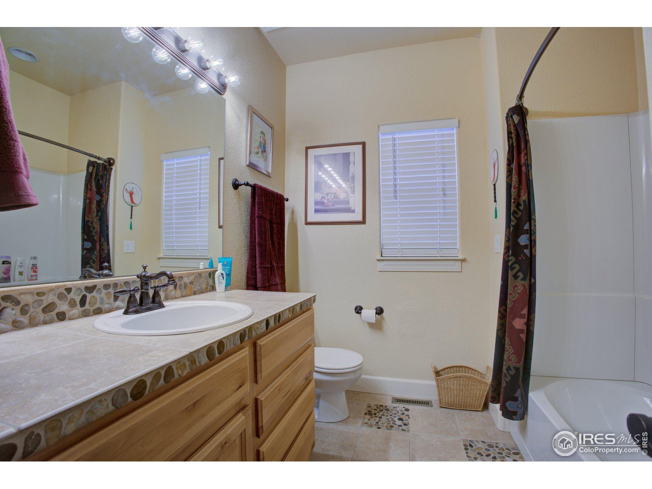 1515 Waterfront Drive Windsor, CO 80550 - Photo 25 of 40 This is the guest bathroom with motion detected lighting and an operable window for sunlight and ventilation. It has a ceramic tile countertop and floor