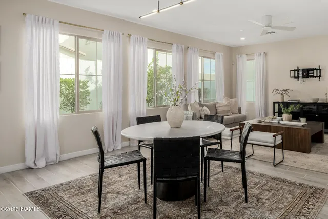 a kitchen with granite countertop a sink a stove a dining table and chairs
