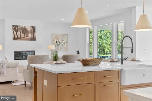 a living room with furniture kitchen and a large window