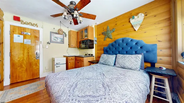 a bedroom with a bed and wooden floor