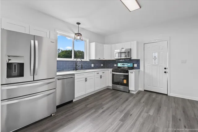 a kitchen with granite countertop a sink cabinets and stainless steel appliances