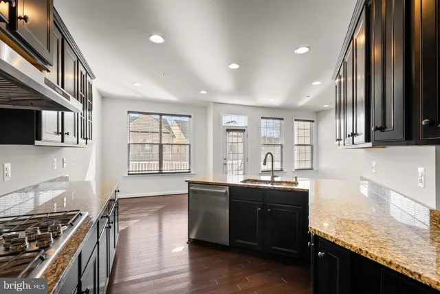 a kitchen with granite countertop a sink stove and cabinets