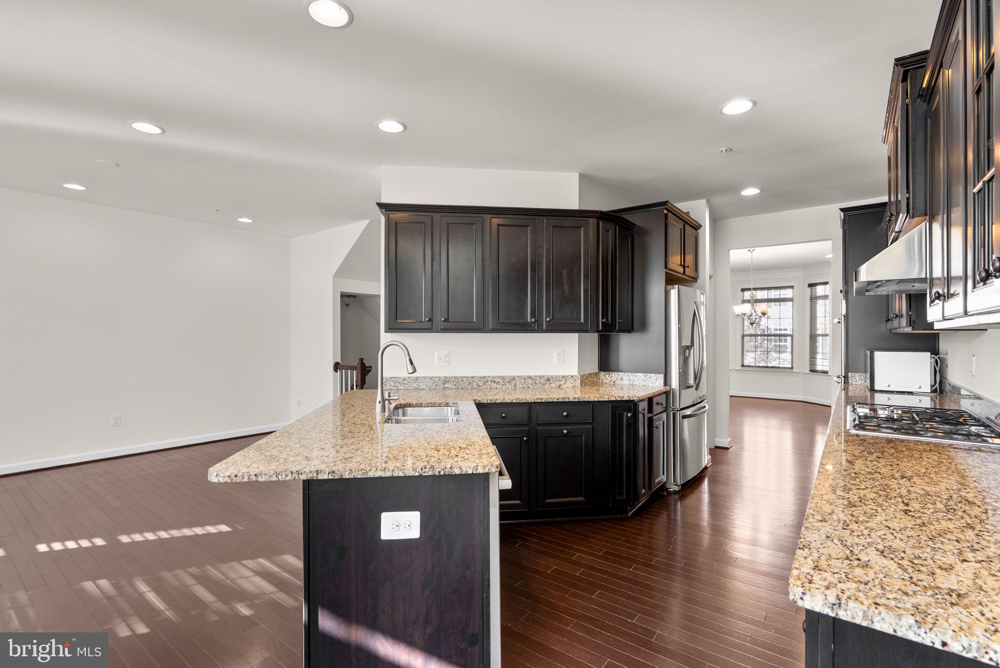 176 Autumn View Drive Gaithersburg, MD 20878 - Photo 16 of 45 a kitchen with stainless steel appliances granite countertop a sink a stove and a wooden floors