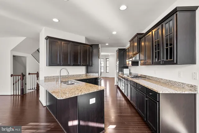 a kitchen with stainless steel appliances granite countertop a sink stove and cabinets