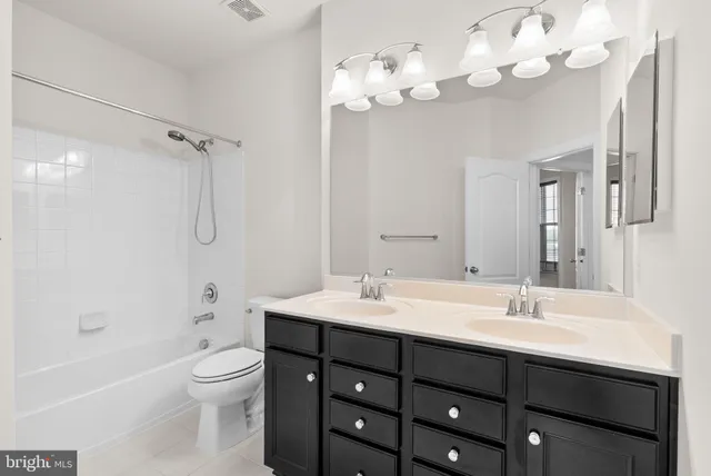 a bathroom with a sink vanity mirror and toilet