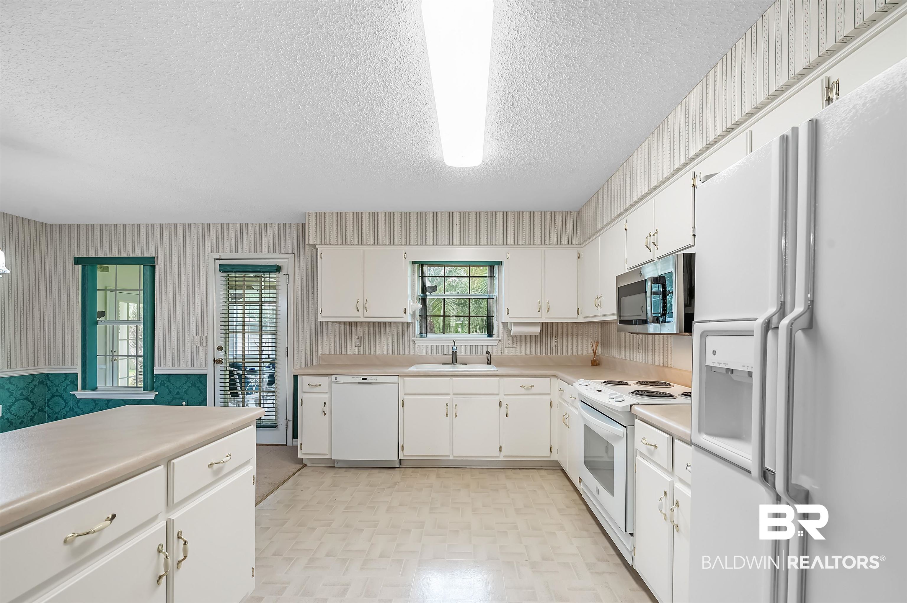 1502 Mulberry Lane Foley, AL 36535 - Photo 11 of 45 Kitchen with white cabinets, white appliances, sink, and a textured ceiling