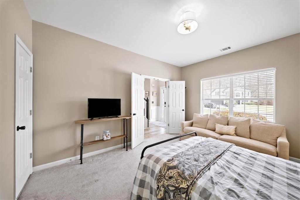 429 Farmwood Way Canton, GA 30115 - Photo 21 of 56 a bedroom with a bed and a flat screen tv
