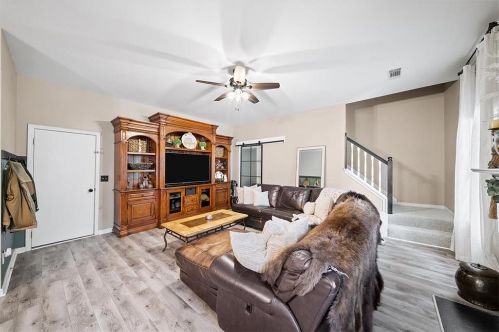 429 Farmwood Way Canton, GA 30115 - Photo 6 of 56 a living room with furniture a flat screen tv and a ceiling fan