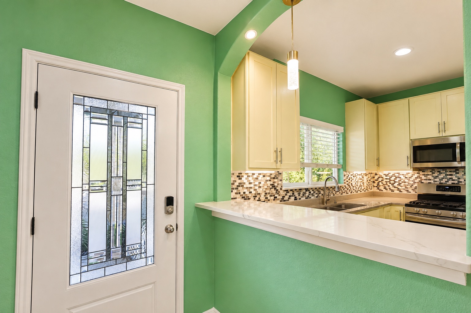 130 Los Arcos Road Elgin, TX 78621 - Photo 6 of 39 A well-equipped kitchen with warm cabinetry and mosaic tile backsplash adjoins a decorative glass-paneled entry door.