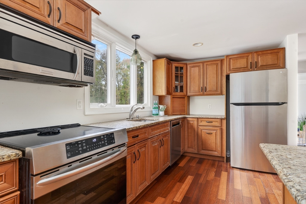 59 First Parish Road Norwell, MA 02061 - Photo 14 of 37 a kitchen with stainless steel appliances granite countertop a stove a refrigerator and a microwave