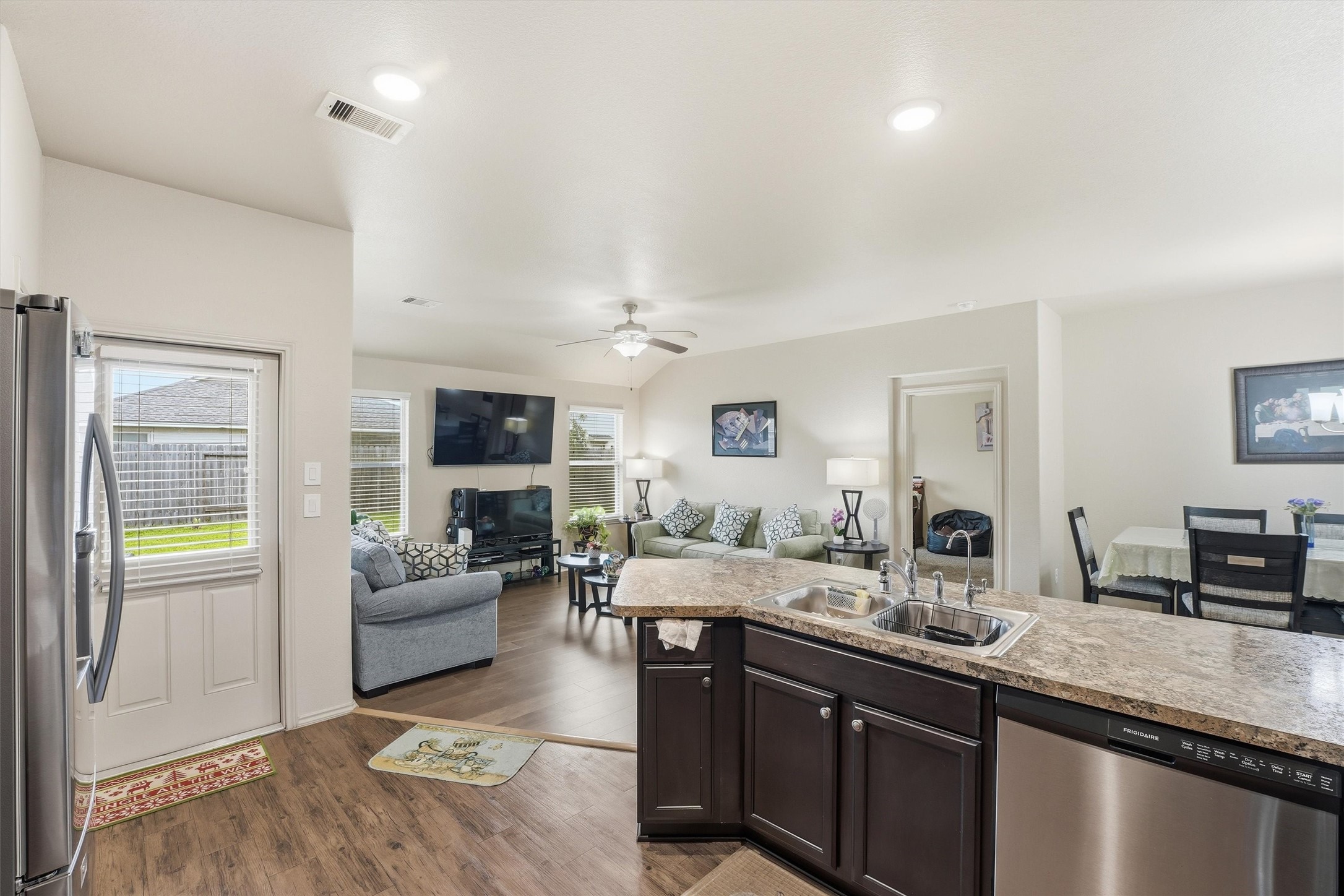 15455 Rancho Joya Way Houston, TX 77049 - Photo 7 of 20 a large living room with stainless steel appliances granite countertop couches a fireplace and a large window with wooden floor