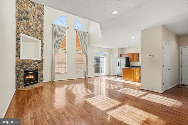 a view of open kitchen with wooden floor and a fireplace