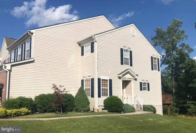 a view of a white house next to a yard with big trees