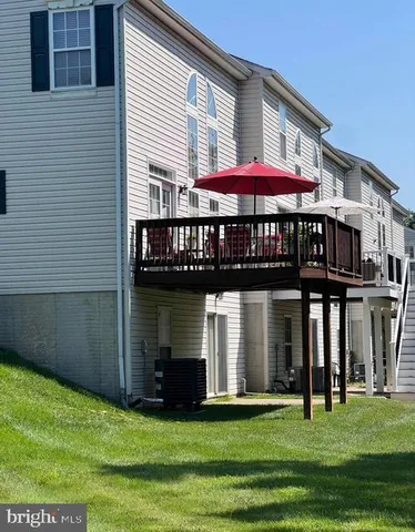 a view of a white house with a big yard and potted plants