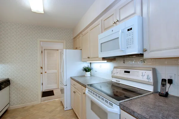 a kitchen with stainless steel appliances granite countertop a refrigerator and a stove