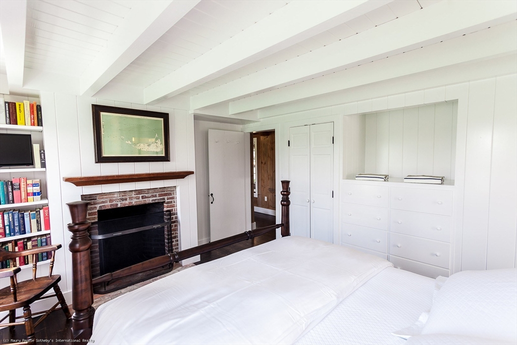 21 Quidnet Road, Unit 1 Nantucket, MA 02554 - Photo 24 of 42 a bedroom with a bed and a fireplace