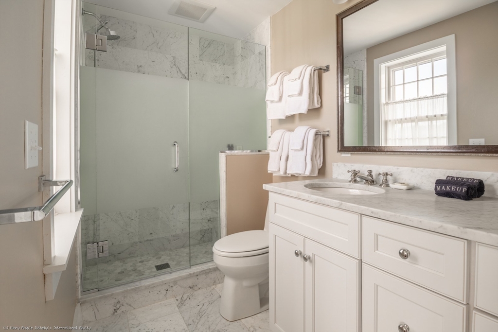 21 Quidnet Road, Unit 1 Nantucket, MA 02554 - Photo 27 of 42 a bathroom with a granite countertop sink a toilet and shower