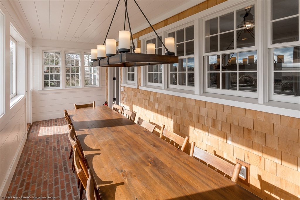 21 Quidnet Road, Unit 1 Nantucket, MA 02554 - Photo 37 of 42 a dining room with wooden floor and large windows