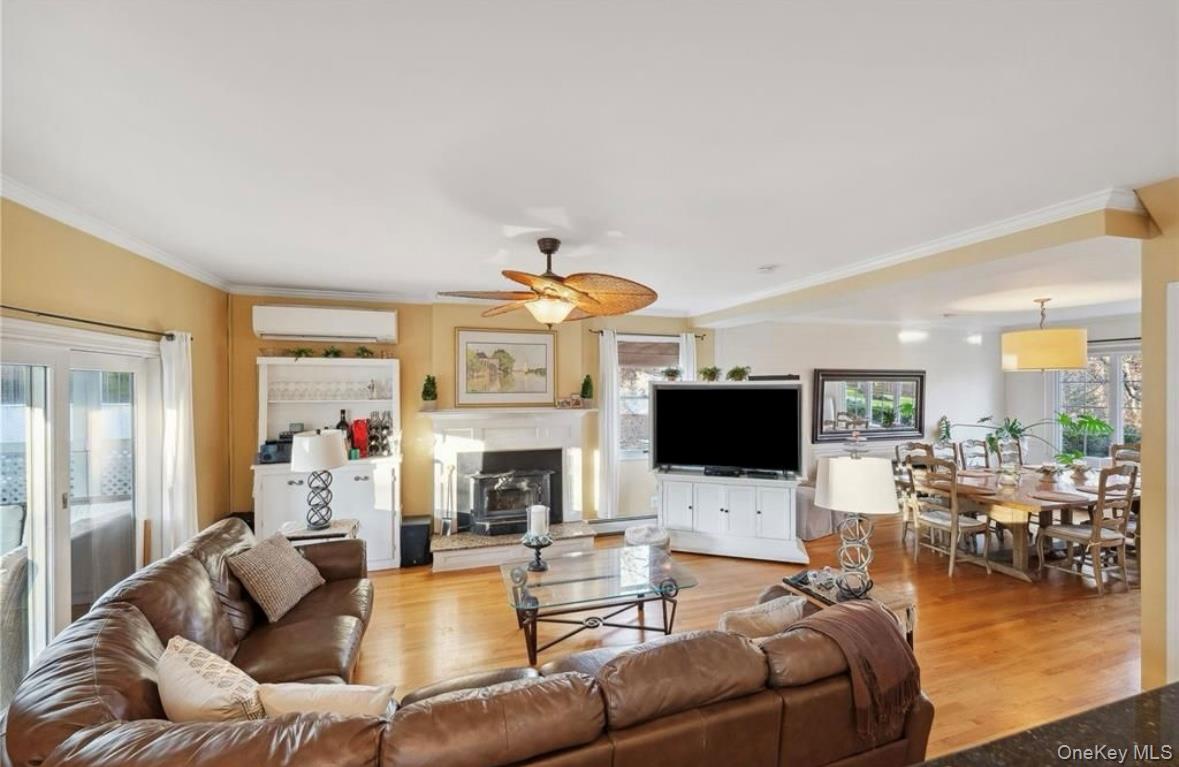 23 North Westbury Road Hampton Bays, NY 11946 - Photo 6 of 19 a living room with furniture a fireplace and a flat screen tv