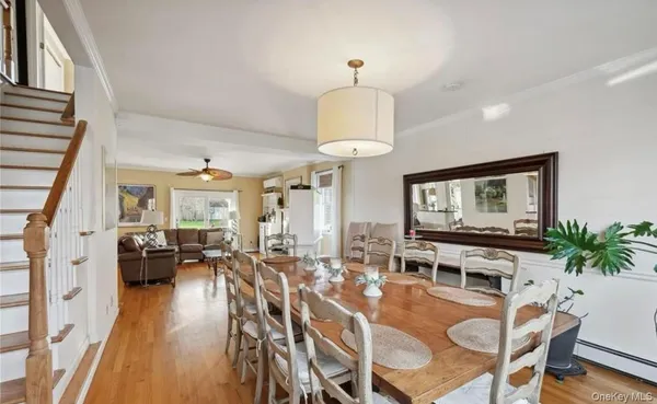 a view of a dining room with furniture a chandelier and wooden floor