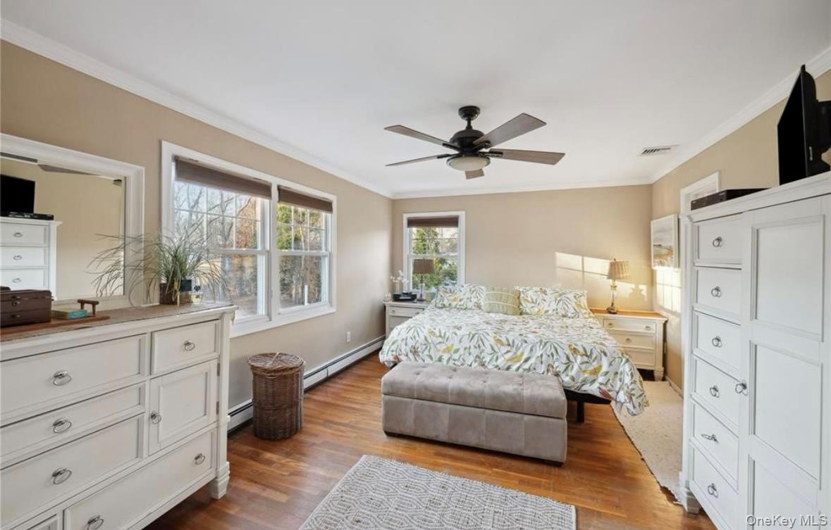 23 North Westbury Road Hampton Bays, NY 11946 - Photo 8 of 19 a spacious bedroom with a large bed and a flat screen tv