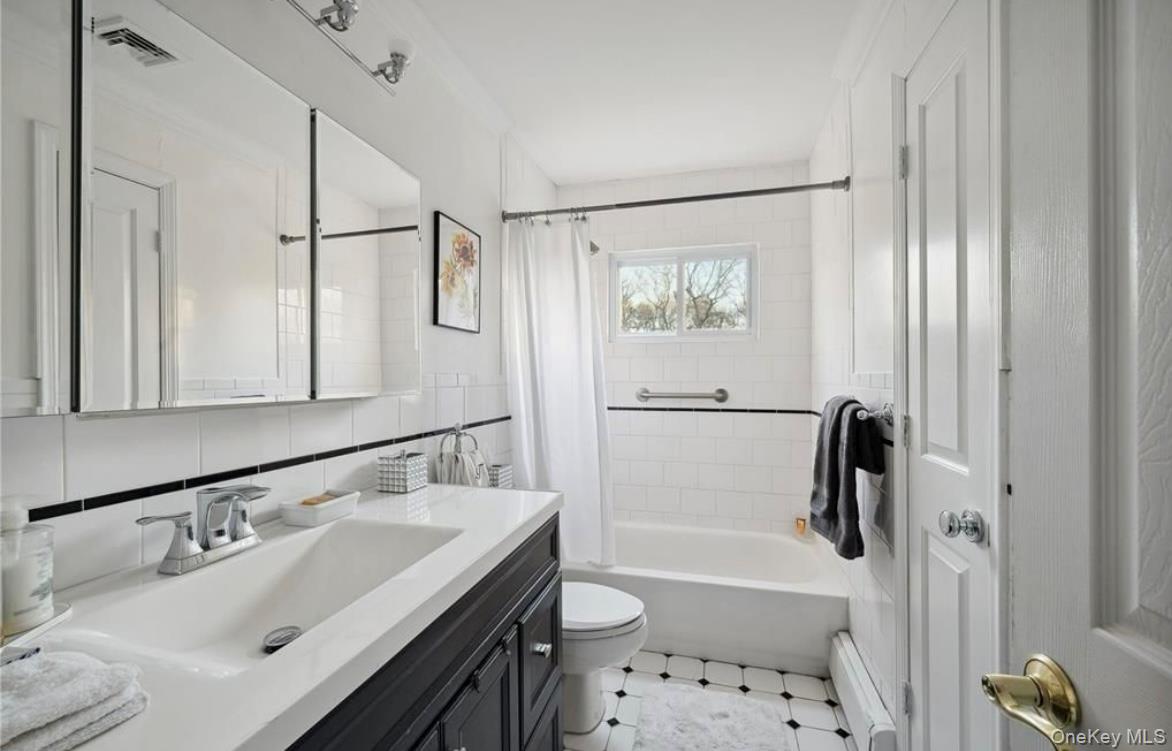 23 North Westbury Road Hampton Bays, NY 11946 - Photo 9 of 19 a bathroom with a sink toilet tub and shower