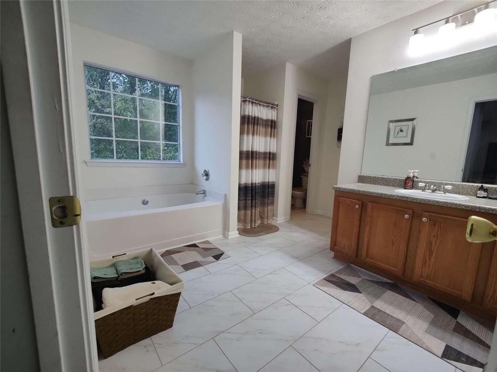 1600 Keystone Drive Conley, GA 30288 - Photo 11 of 14 a bathroom with a tub sink and a mirror