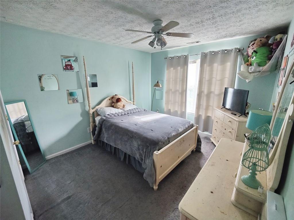 1600 Keystone Drive Conley, GA 30288 - Photo 8 of 14 a bedroom with a bed wooden floor and a flat tv screen on dresser