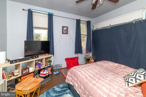 a bedroom with a bed a flat screen tv and dresser