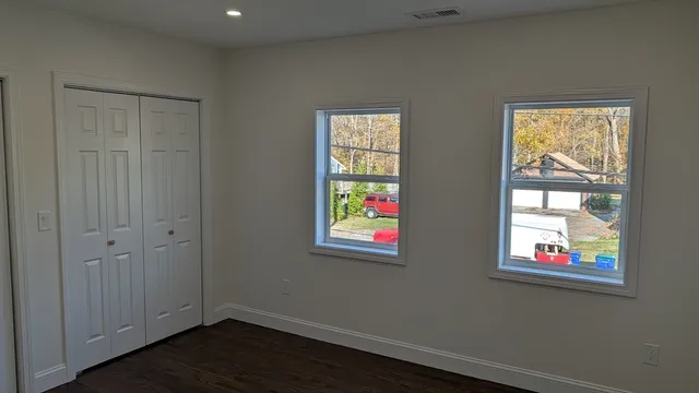 an empty room with windows and closet