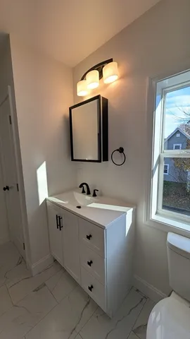 a bathroom with a toilet sink and mirror