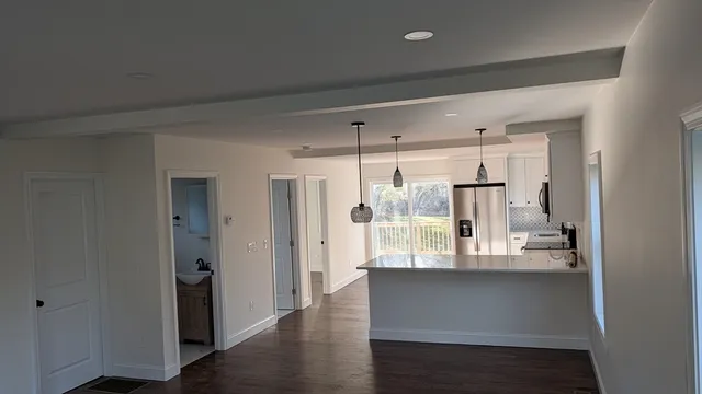 a room with wooden floor and white cabinets