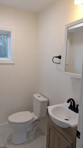 a white toilet sitting next to a bathroom sink