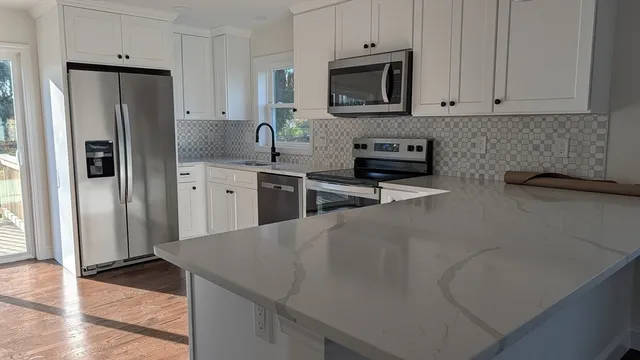 a kitchen with stainless steel appliances a refrigerator stove microwave and sink