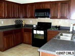 138 Rambler Lane Blacksburg, SC 29702 - Photo 6 of 8 a kitchen with granite countertop wooden cabinets and a stove top oven