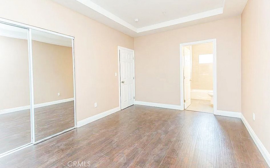229 East 84th Street, Unit 229 Los Angeles, CA 90003 - Photo 2 of 5 an empty room with wooden floor and a window