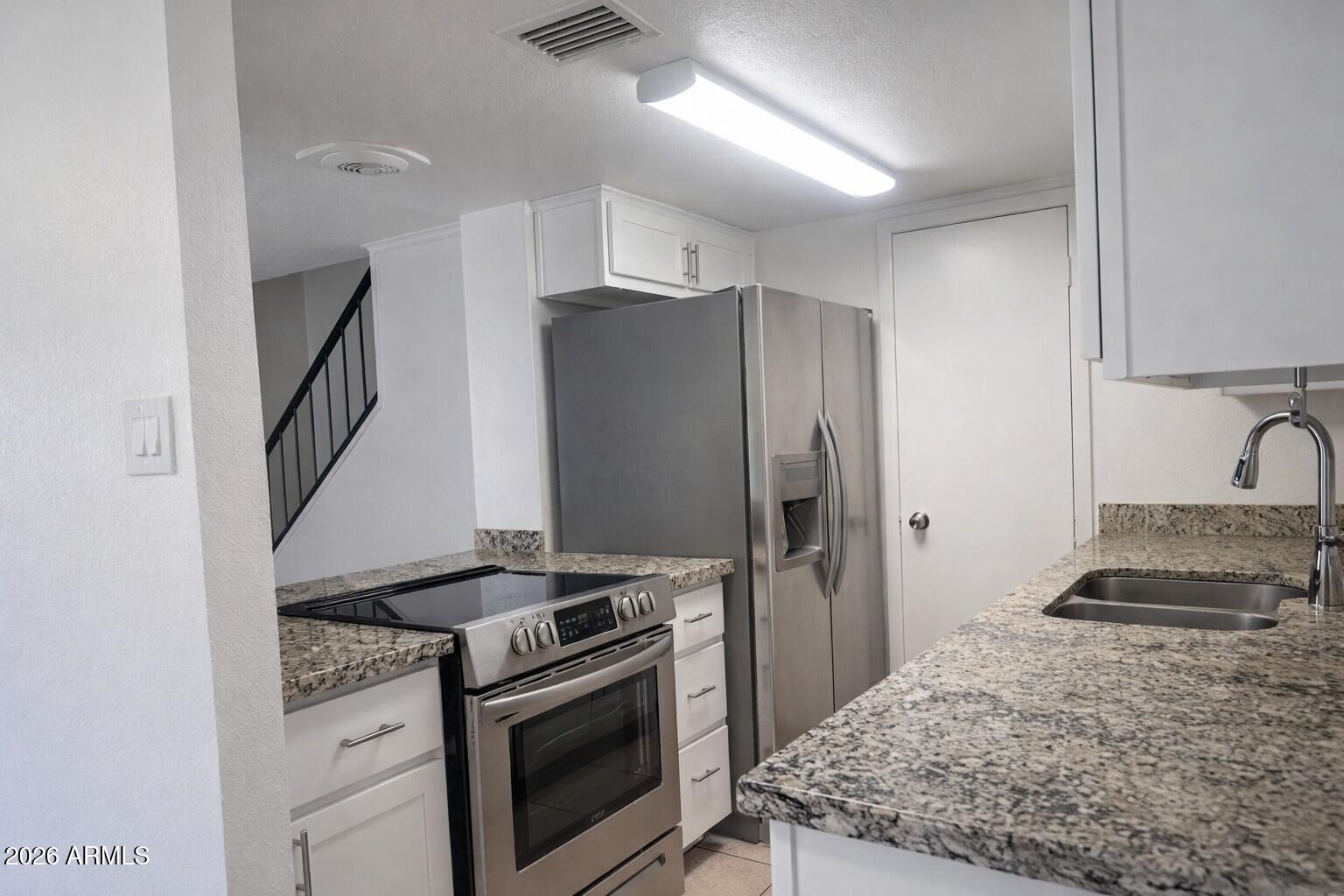 4043 West Wonderview Road Phoenix, AZ 85019 - Photo 4 of 10 a kitchen with a stove and a refrigerator