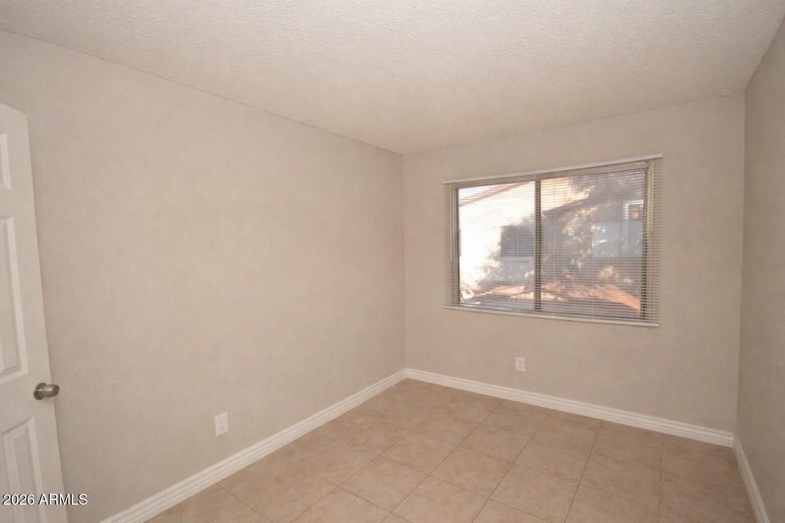 4043 West Wonderview Road Phoenix, AZ 85019 - Photo 5 of 10 an empty room with a window