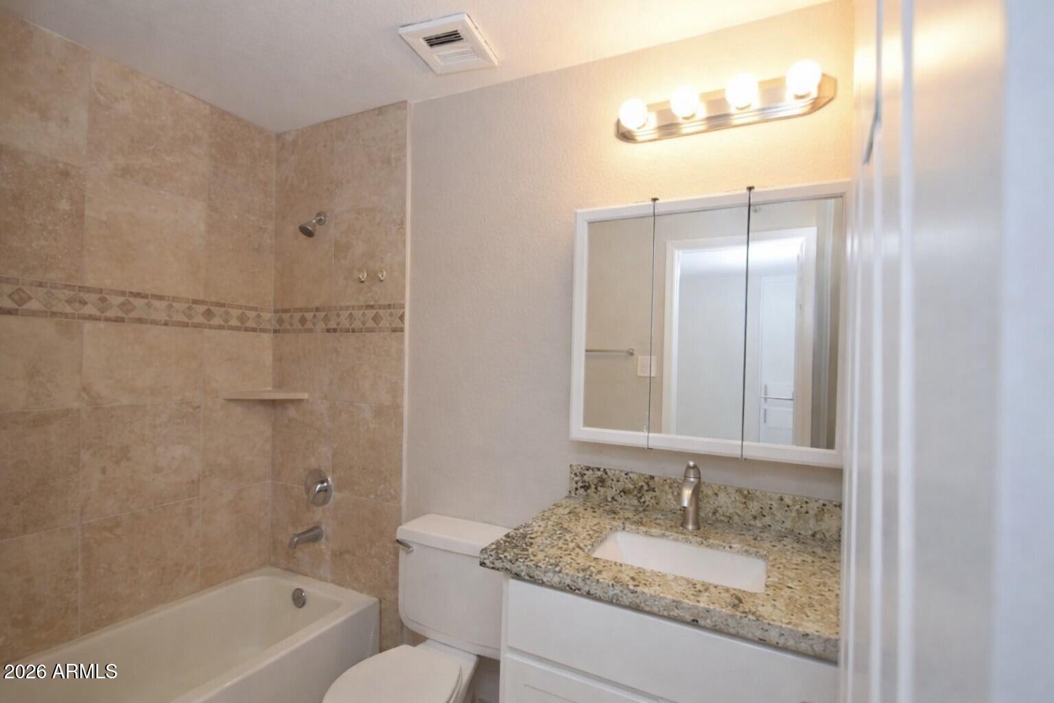 4043 West Wonderview Road Phoenix, AZ 85019 - Photo 6 of 10 a bathroom with a granite countertop sink toilet and shower