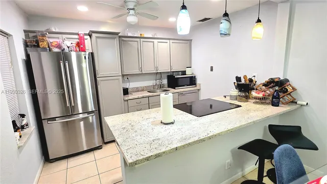 a kitchen with stainless steel appliances granite countertop a sink refrigerator and microwave