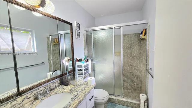 a bathroom with a granite countertop sink toilet and shower