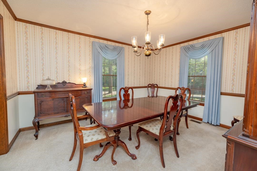 6509 Woodshire Place Raleigh, NC 27612 - Photo 11 of 30 a view of a dining room with furniture and a chandelier