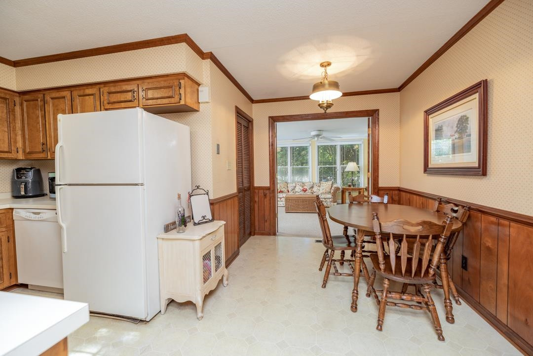 6509 Woodshire Place Raleigh, NC 27612 - Photo 13 of 30 a dining room with furniture and a refrigerator