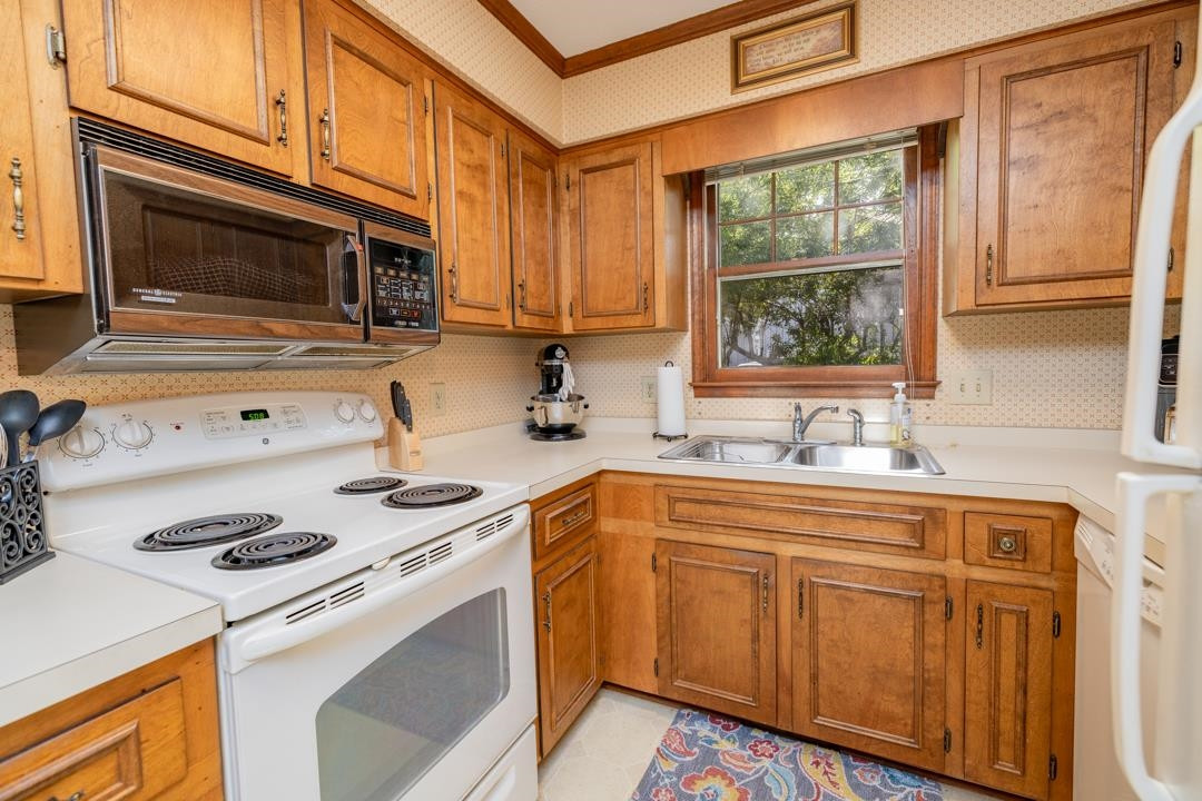6509 Woodshire Place Raleigh, NC 27612 - Photo 15 of 30 a kitchen with stainless steel appliances white cabinets and a stove top oven