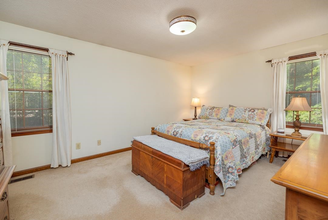 6509 Woodshire Place Raleigh, NC 27612 - Photo 16 of 30 a spacious bedroom with a bed and wooden floor