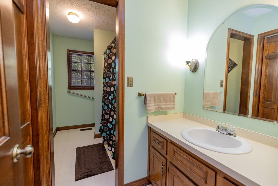 6509 Woodshire Place Raleigh, NC 27612 - Photo 22 of 30 a bathroom with a sink a toilet and shower