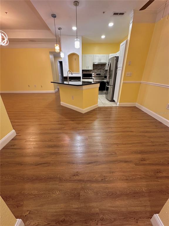 3280 Soho Street, Unit 308 Orlando, FL 32835 - Photo 11 of 45 a view of a kitchen with kitchen island a sink stainless steel appliances and cabinets